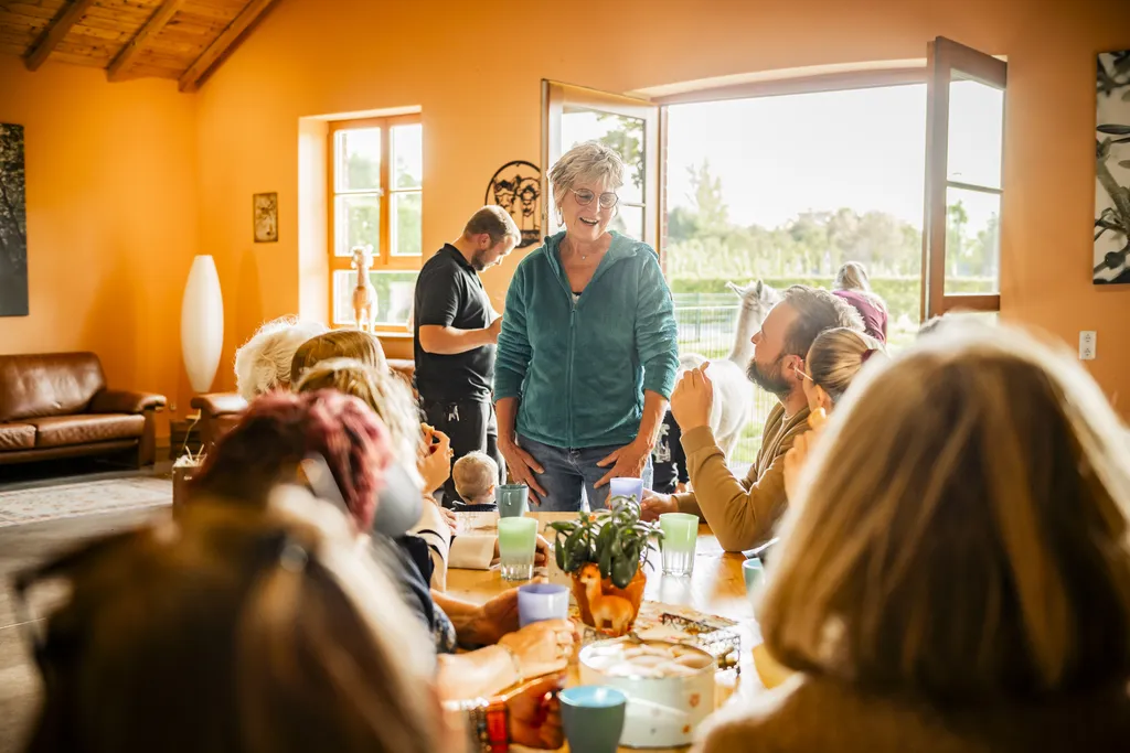Heike begrüßt Gäste am gedeckten Tisch im Eventraum