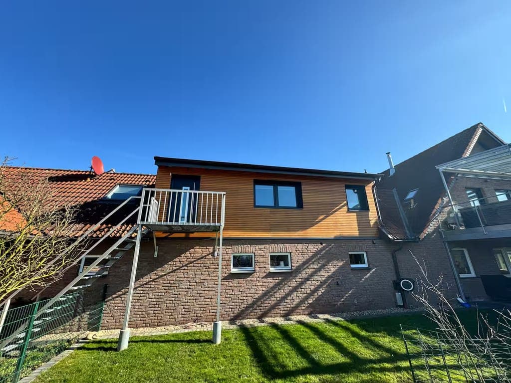 Ferienwohnung des Alpakahofs Seibt von außen: Holzfassade, Balkon und Garten